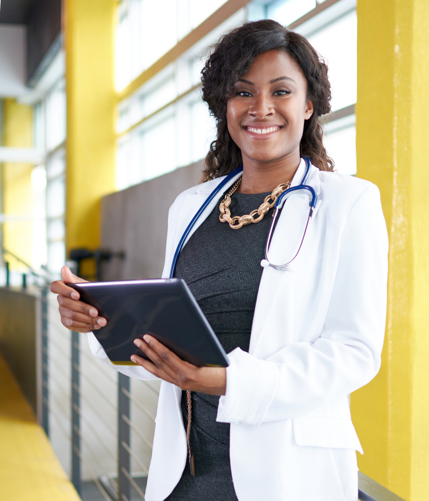 Portrait of a female doctor holding her patient chart on digital tablet in bright modern hospital Portrait of a female doctor holding her patient chart on digital tablet in bright modern hospital